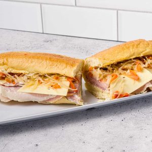 Royal Polish Delight – Kanapka Królewska. Smoked baleron, Polish ham, Genoa salami, and Polish cheese layered with garlic mayo and Old Polish salad on a warm hoagie roll. A true taste of Poland.
